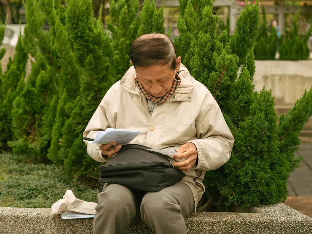 Persona mayor revisando documentos al aire libre